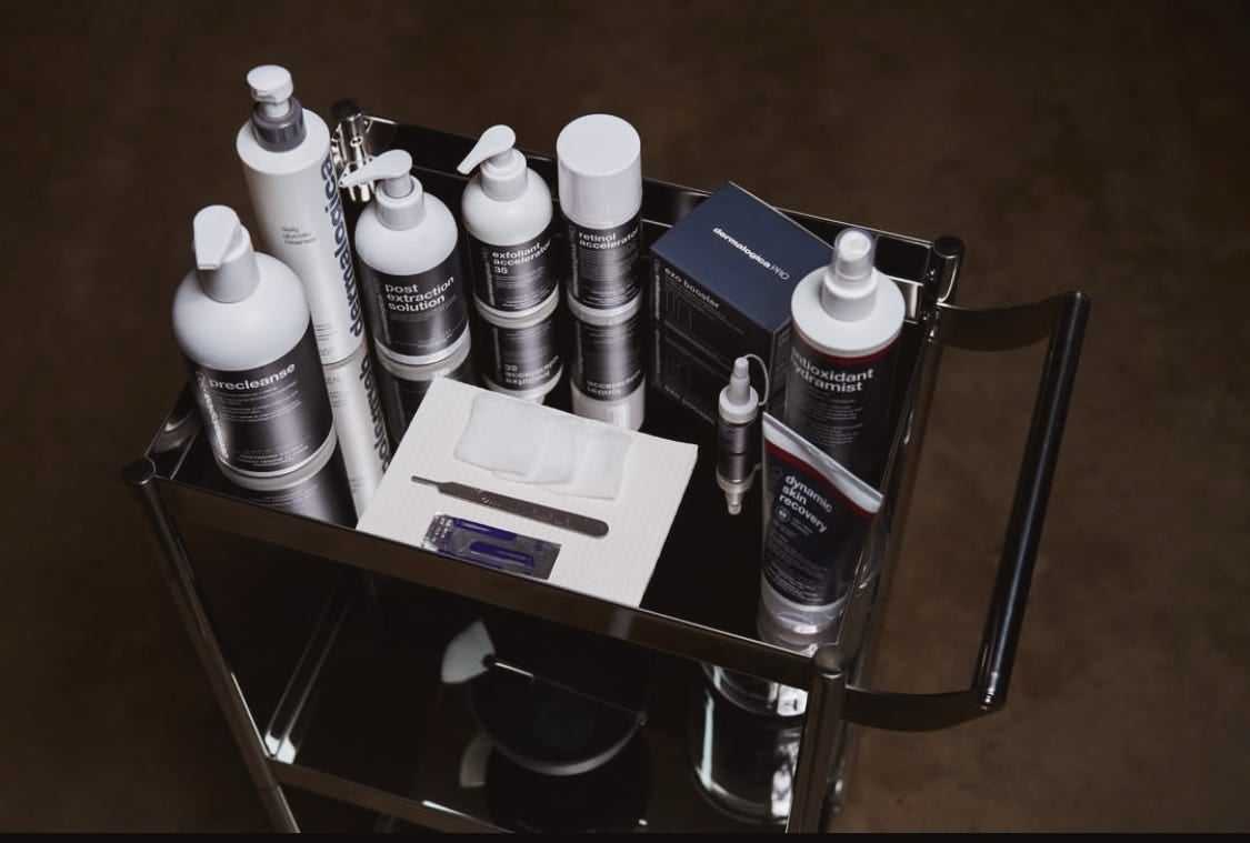 A variety of skincare products neatly arranged on a trolley with dark background.
