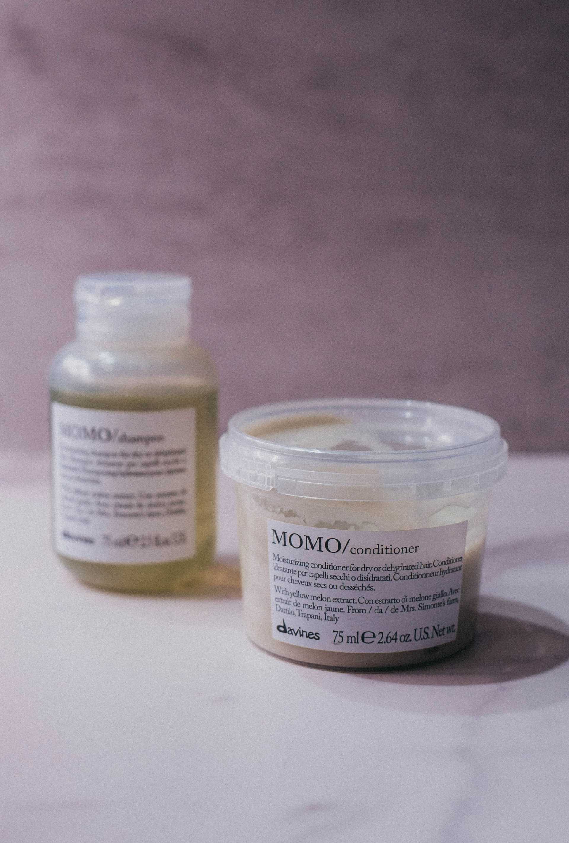 MOMO shampoo and conditioner set on a marble surface.