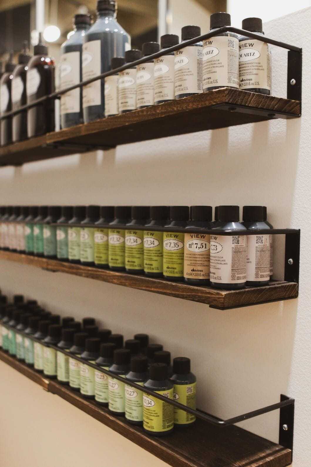 Shelves filled with various paint bottles arranged in a neatly organized display.