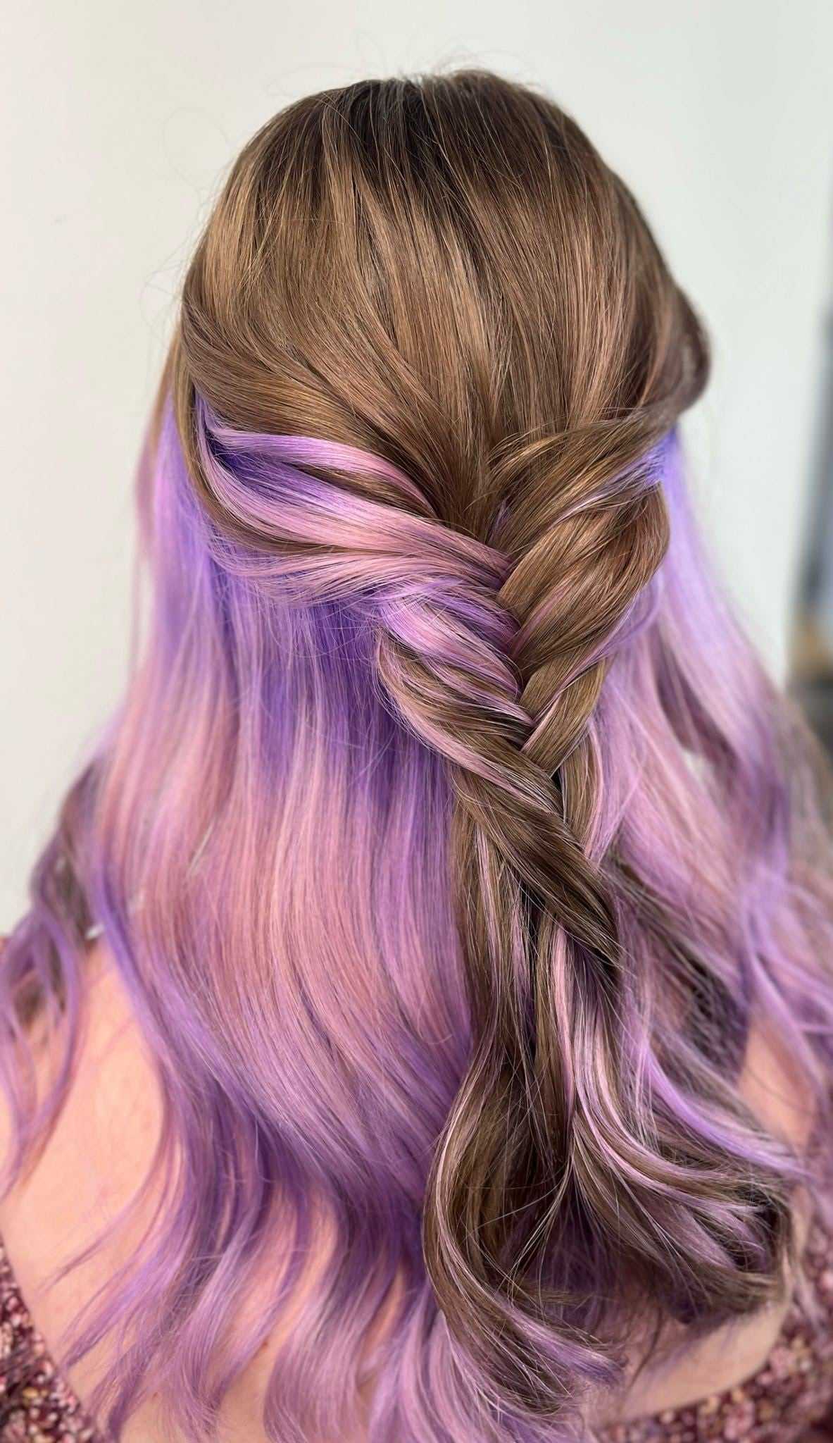 Braided hairstyle with brown and purple hair, elegantly cascading in soft waves.