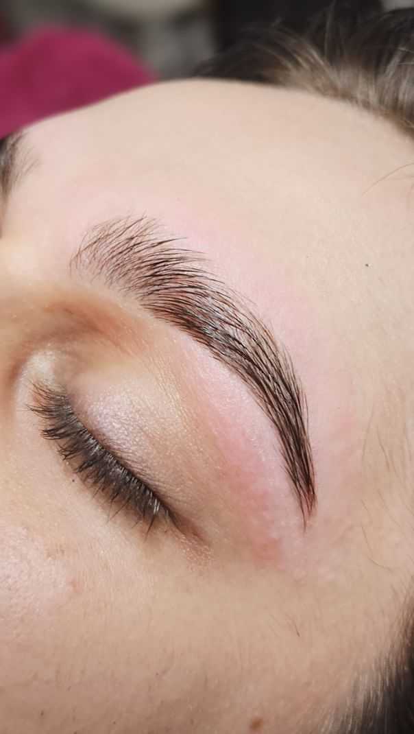 Close-up of a person's perfectly groomed eyebrow with closed eyelid.